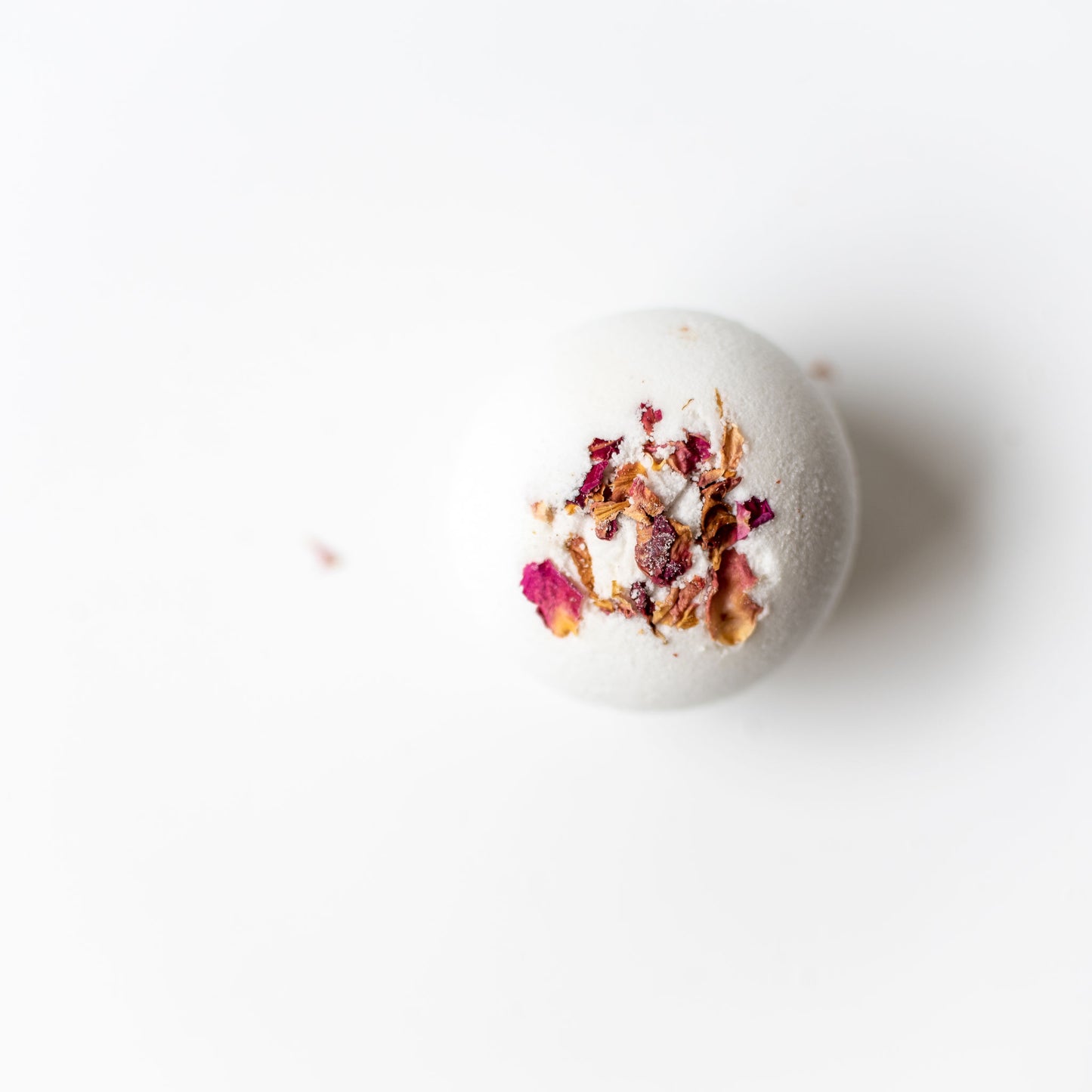 Bath bomb with dried flowers on a white background