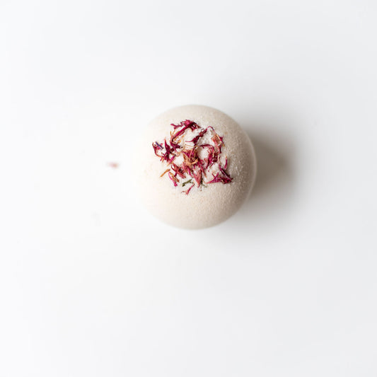 Bath bomb with dried flowers on a white background