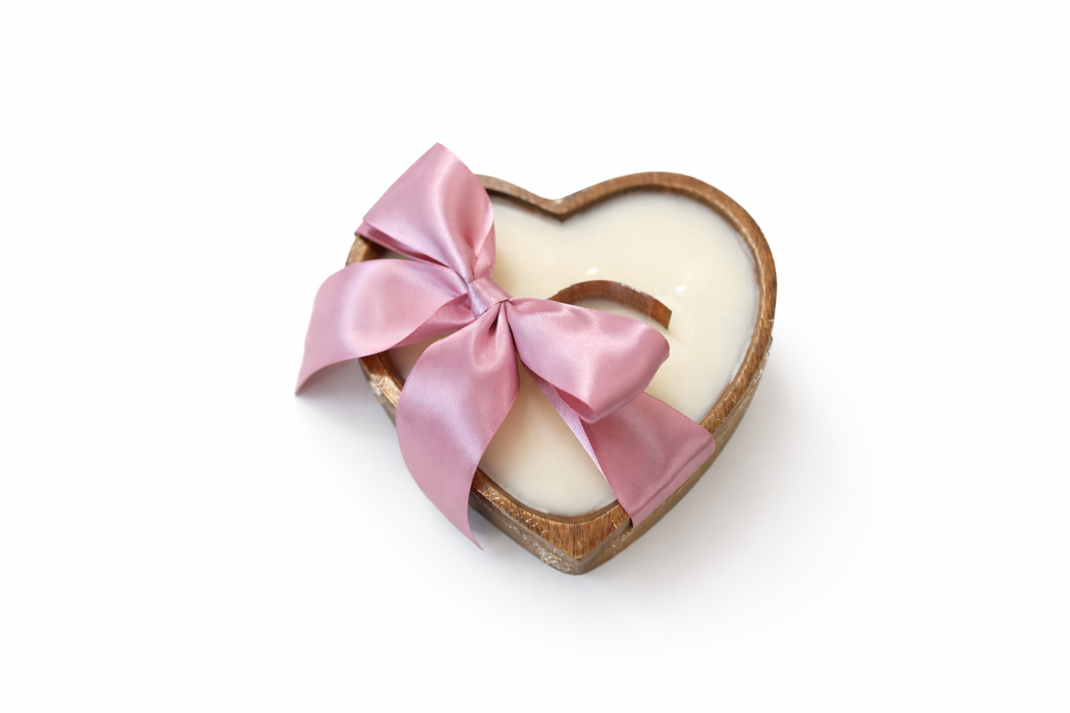 Heart-shaped candle with a pink ribbon on a white background