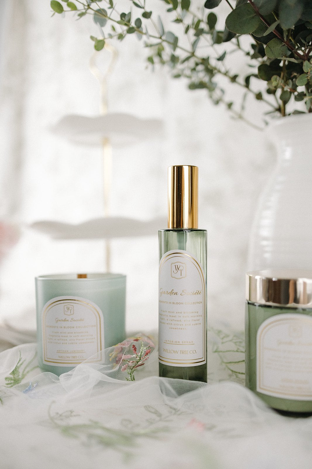 Three skincare products on a white surface with a blurred background