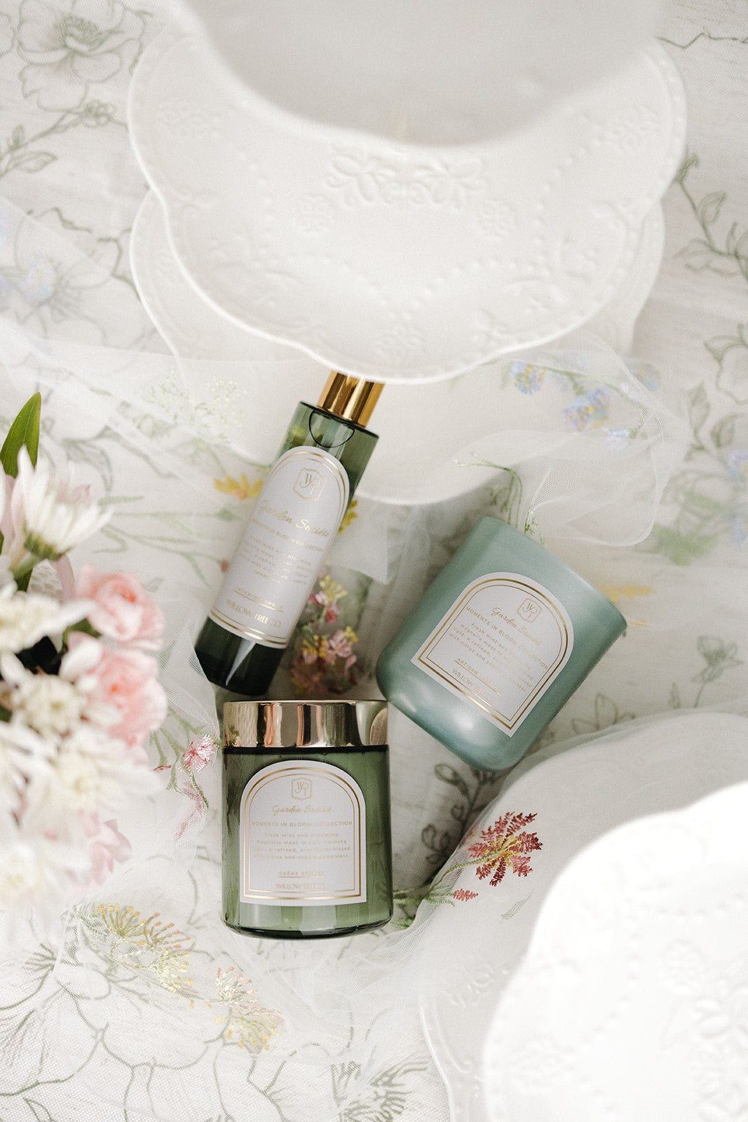 Set of skincare products on a floral-patterned surface with a white bowl above.
