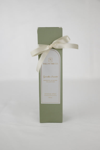 Green gift box with a white label and ribbon on a light gray background