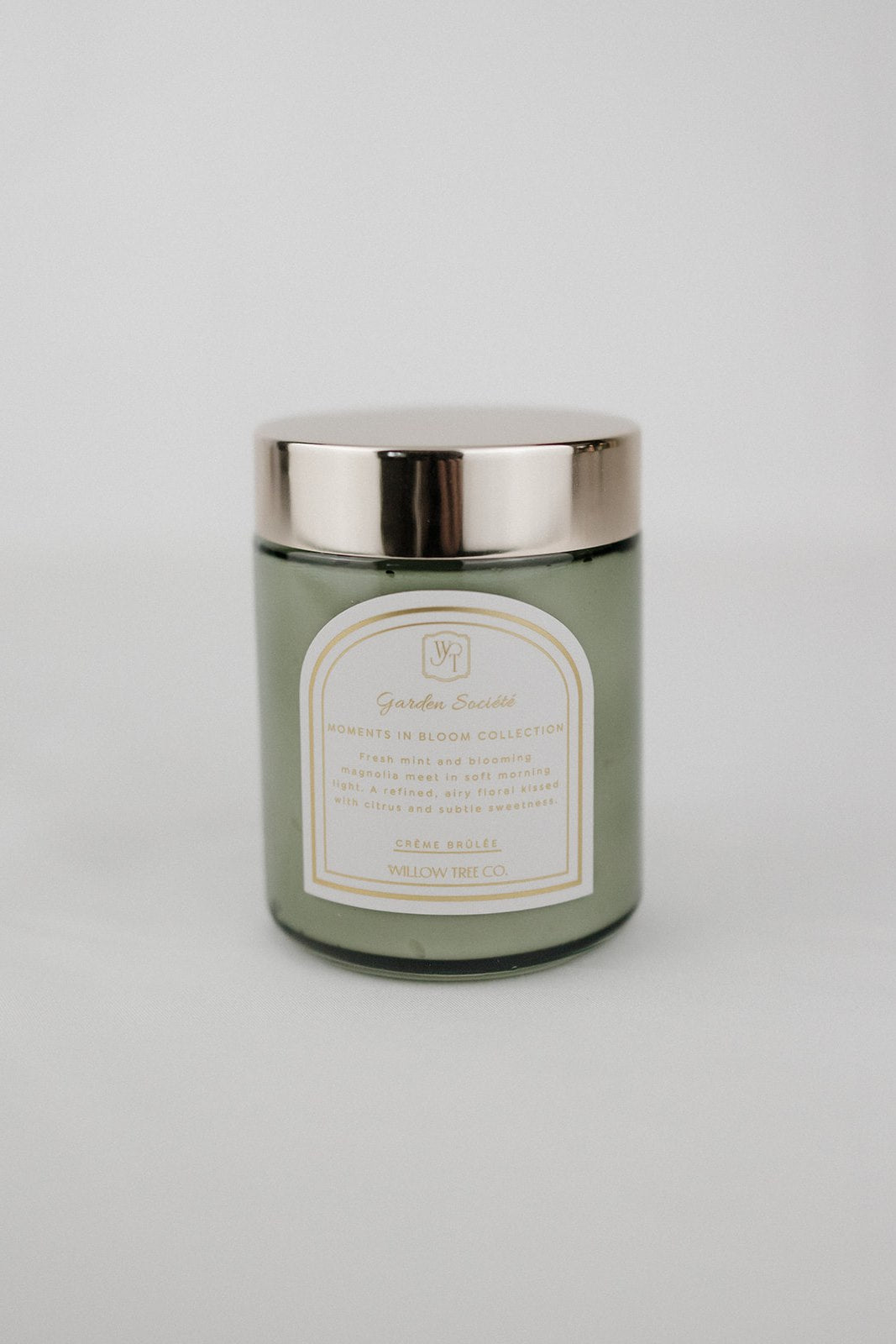 Green body cream jar with silver lid on a light gray background