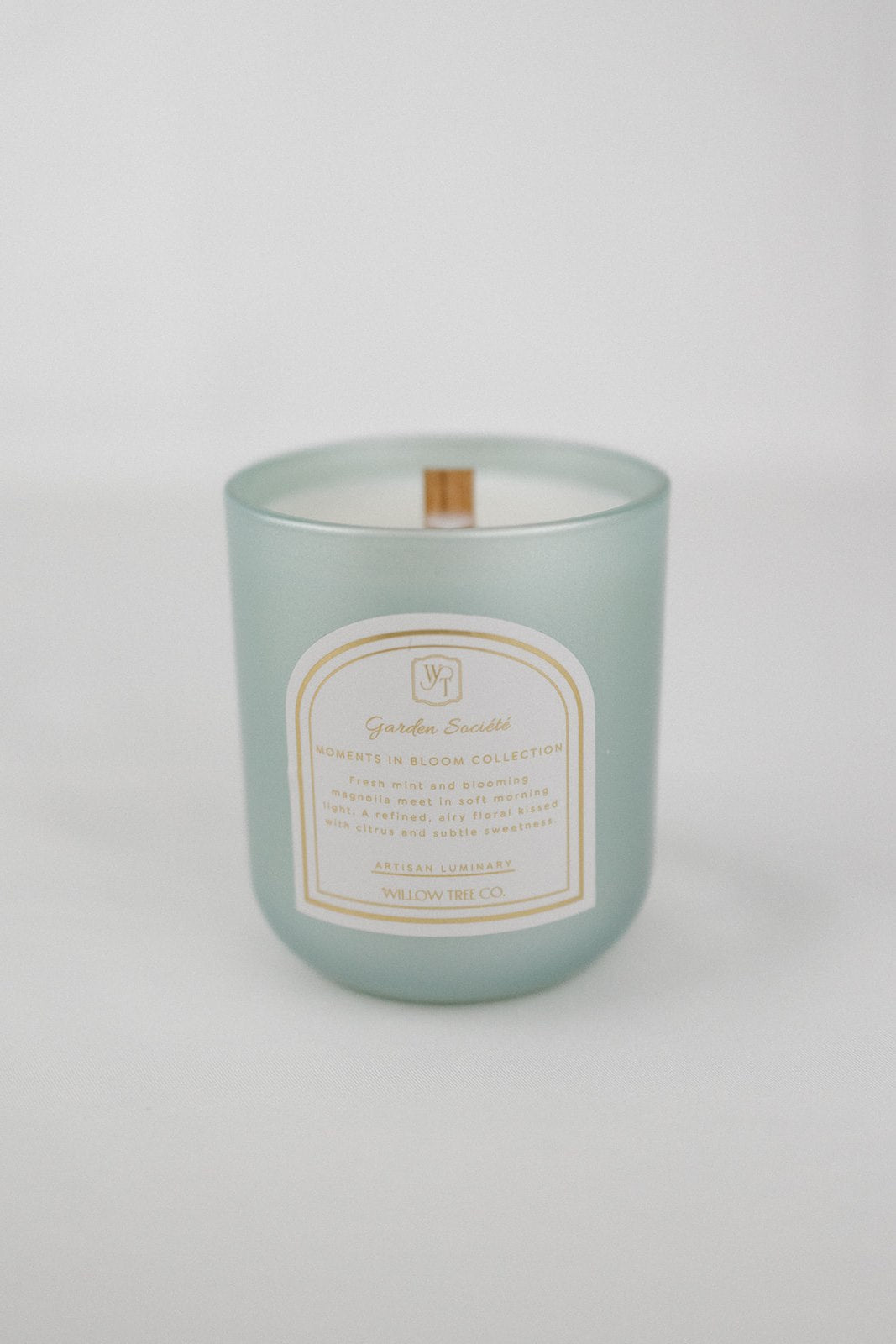 Pearl mint green candle with a label on a white background