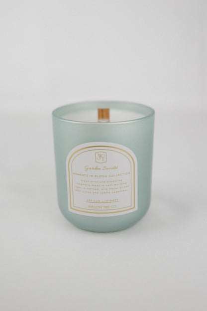 Pearl mint green candle with a label on a white background
