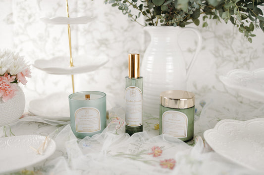 interior spray, body cream, and a candle on a white surface with floral decorations