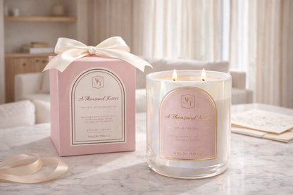 White candle with pink label and matching pink packaging box on a marble surface.