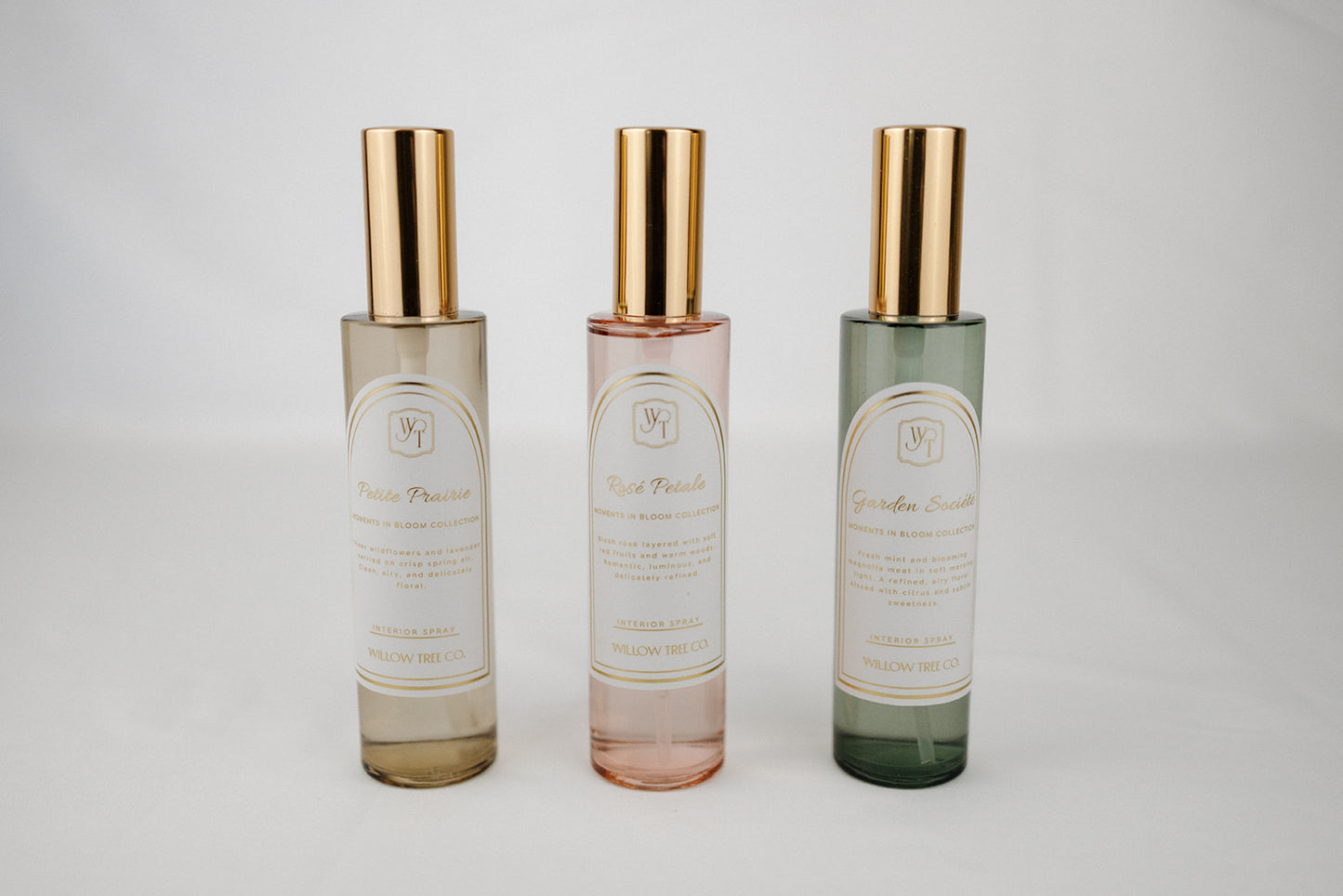Three glass bottles with gold caps on a light gray background