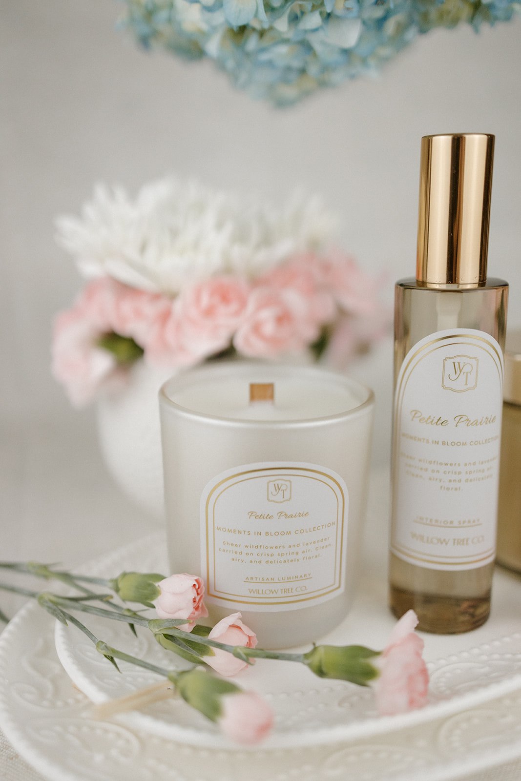 Candle and interior spray with floral arrangement in the background