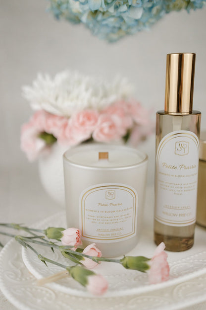 Candle and interior spray with floral arrangement in the background