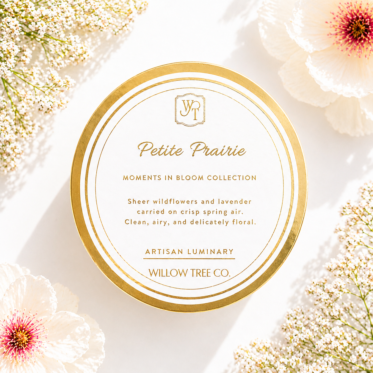 Petite Prairie luxury spring candle with gold lid surrounded by soft wildflowers and airy floral styling in bright natural light