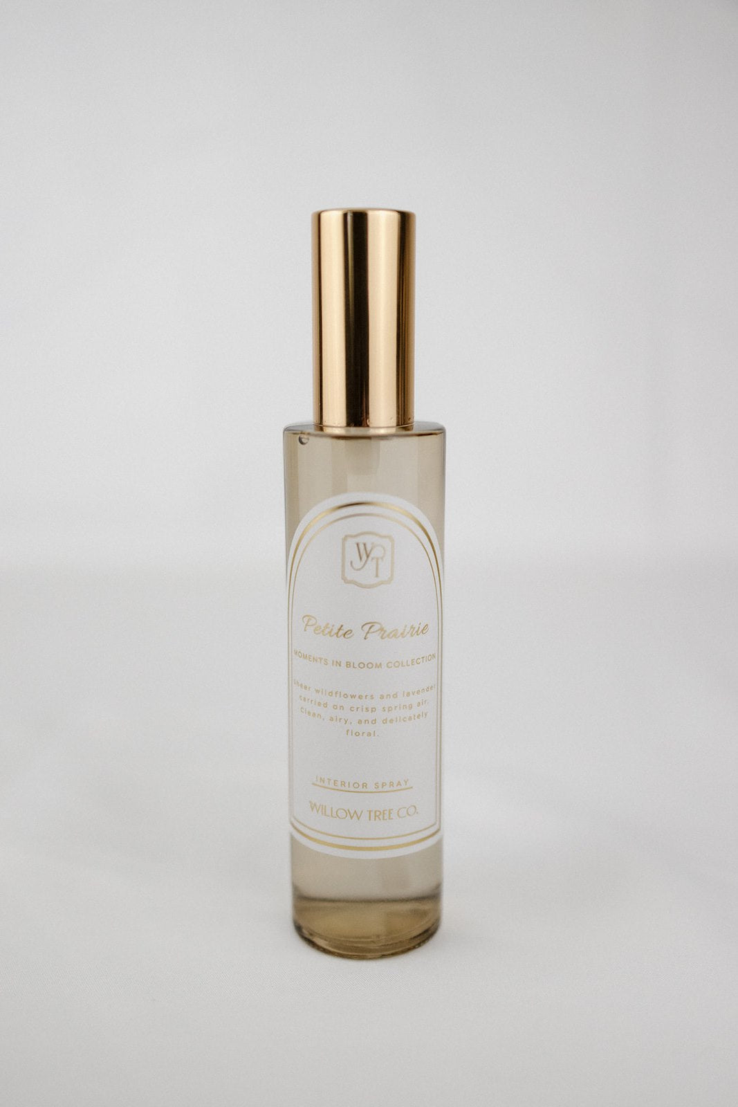 Gold interior spray with gold cap on a light gray background