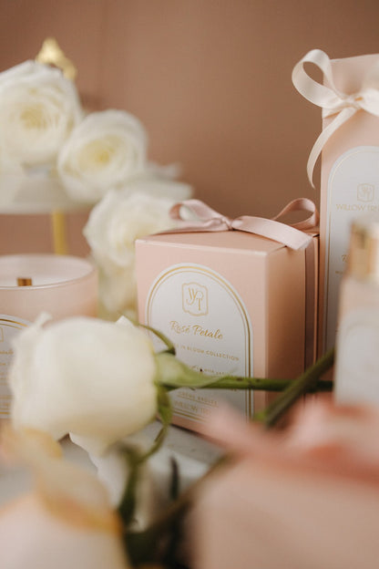 Gift box with a bow and floral arrangement on a blurred background