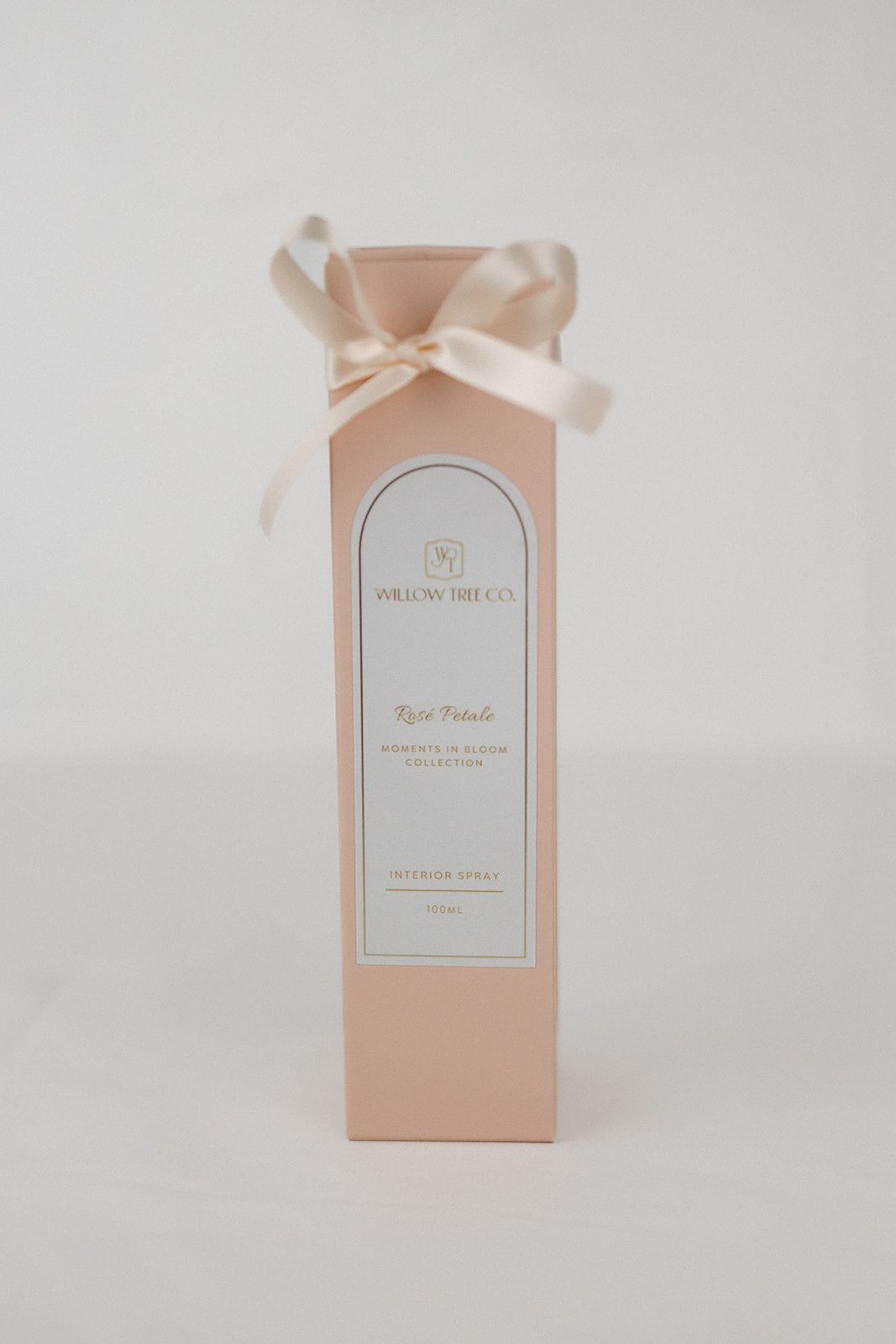 Pink gift box with a white label and ribbon on a light gray background