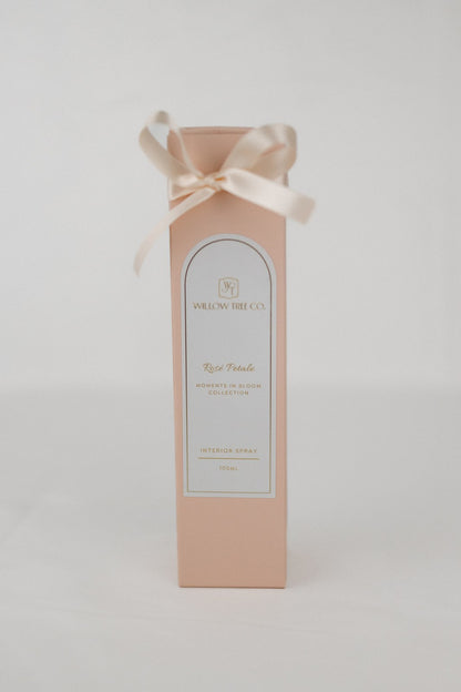 Pink gift box with a white label and ribbon on a light gray background