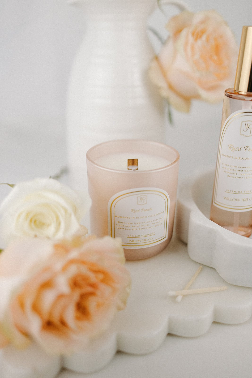Candle and interior spray with floral arrangement on a light surface