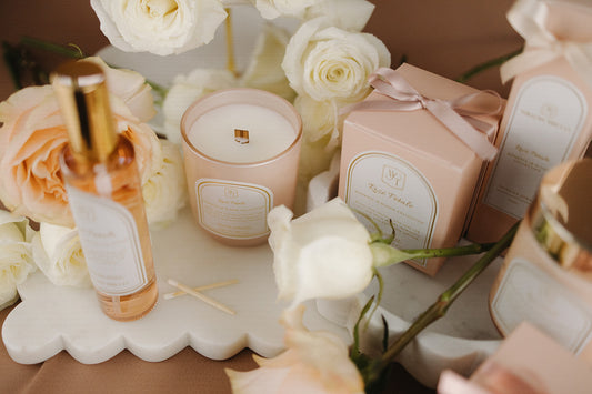 Decorative setup with candles, flowers, and gift boxes on a table.